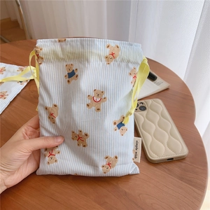 Detailed view of a striped cotton drawstring pouch with cute brown bear prints