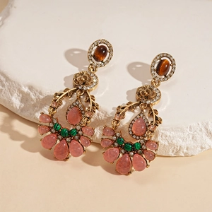 Detailed macro view of vintage gold earrings with colorful resin stones and floral inlay