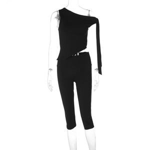 Detail eines schwarzen asymmetrischen One-Shoulder-Oberteils und schmalen High-Waist-Hosen