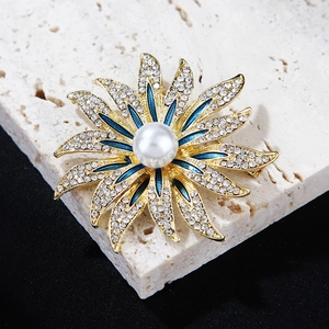 Macro shot of sun flower brooch with blue enamel petals and sparkling rhinestones