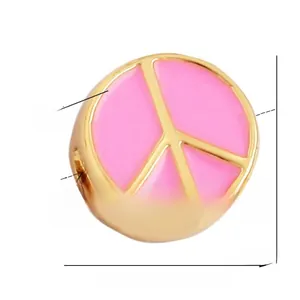 Detail view of pink enamel peace sign bead with gold finish and 10mm diameter specs