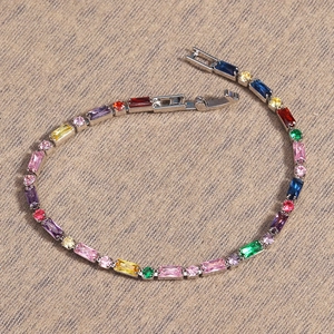 Detailed macro view of gold plated bracelet with multicolored cubic zirconia gemstones