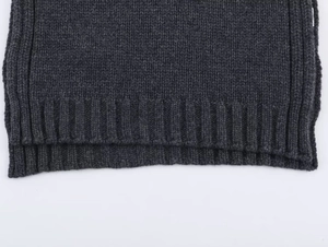 Detail of dark grey wool blend vest featuring a side slit and ribbed knit hemline