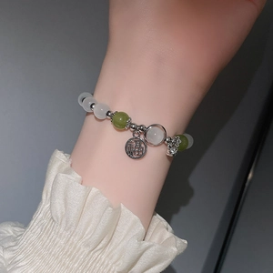 Detail eines Perlenarmbands mit weißen Opalperlen und silbernem Fu-Anhänger