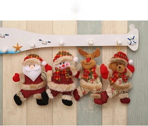 Close-up of four plush Christmas ornaments featuring Santa, snowman, deer and bear