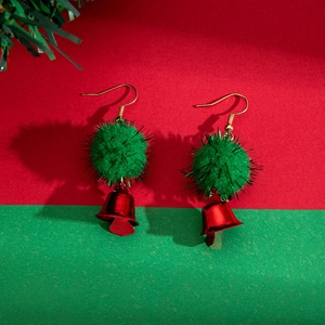 Christmas bow earrings with green pom poms and red bells on festive background