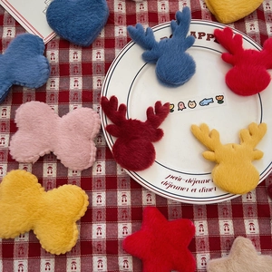 Macro detail of plush reindeer, butterfly and star ornaments on a red checkered cloth
