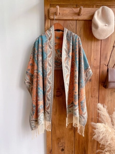 Detail of bohemian ethnic shawl featuring paisley patterns and decorative fringe edges