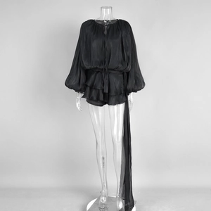 Detail of black chiffon playsuit with lantern sleeves and double-layered ruffle hemline