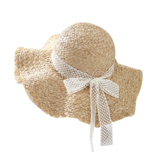 Women's raffia sun hat with wide wavy brim and lace bow for summer beach vacation