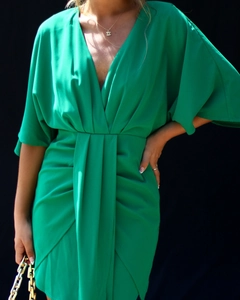 Détail de la robe verte à col en V montrant les plis à la taille et le tissu soyeux