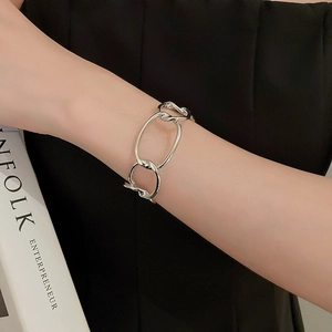 Macro detail of silver thick chain bracelet featuring polished interlocking oval links