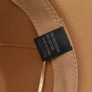 Detail view of brown wool felt hat lining with washing labels showing material composition