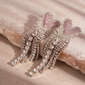 Macro shot of pink heart tassels with rhinestones on a natural stone surface