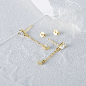 Macro detail of S925 sterling silver stamp on gold chain earrings with opal and zircon