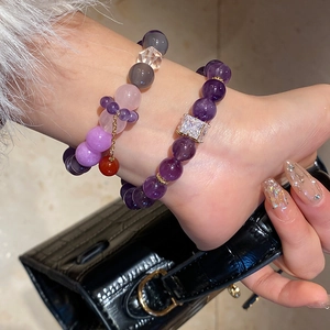 Detail of amethyst and rose quartz beaded bracelet with gold spacers on woman's wrist