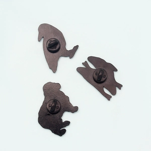 Detailed back view of three black metal pins featuring secure rubber clutch backings