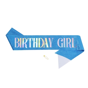 Detail of blue glitter birthday girl sash with holographic text and gold safety pin
