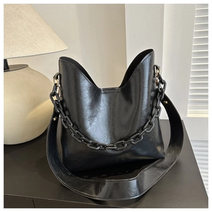 Close-up of black retro oily texture PU leather tote with chunky chain strap detail