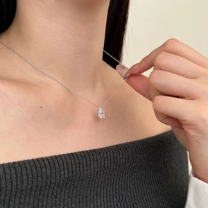 Close-up of a silver S925 necklace with an emerald-cut cubic zirconia pendant on a model