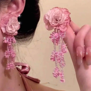 Detail of pink flower earrings with long beaded tassels and shimmering sequins