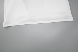 Detailed close-up of white sleek fabric hemline for summer zip-up maxi dress