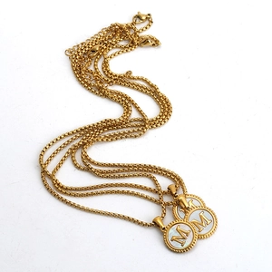 Détails du collier en acier plaqué or 18K avec lettre M et incrustation en nacre