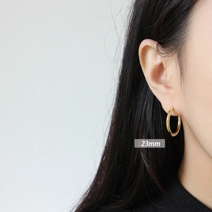 Minimalist S925 sterling silver 23mm gold-plated hoop earrings worn by a model