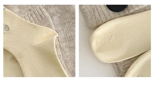 Detail von weichen gelben Stricksocken mit roter Herzstickerei und feiner Rippenstruktur