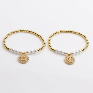 Gold beaded bracelets with pearls and sparkling star and moon pendants in a two-piece set