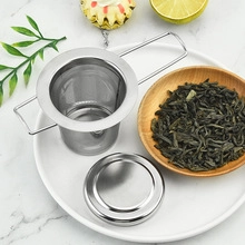 304 stainless steel tea infuser with folding handles on a white plate with lemon