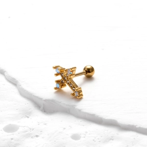 Detailed macro view of a golden cross stud earring with zircon and screw ball back