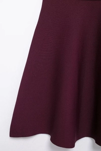 Detail of deep purple knit texture and asymmetric hemline on mini dress