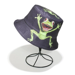 Detail view of a black bucket hat with funny green cartoon frog prints on canvas fabric