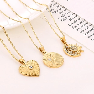 Detail of three gold celestial necklaces with zircon-inlaid star, moon, and heart charms