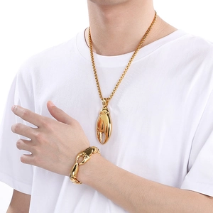 Détail de l'ensemble collier et bracelet avec pendentif pince de crabe doré en acier