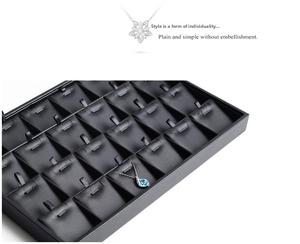 Detail of 24-slot black PU leather jewelry tray with hooks for pendants and necklaces