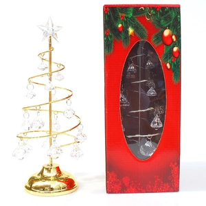 Macro detail of a spiral gold metal Christmas tree with crystal pendants and gift box