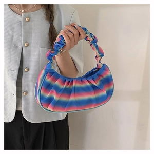 Close-up of rainbow gradient pleated cloud bag worn by a model on a shoulder