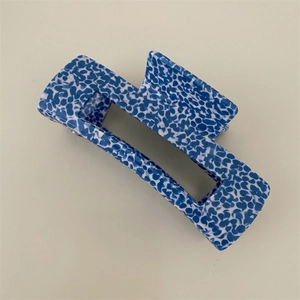Macro view of blue floral pattern on rectangular hollow hair claw clip accessory