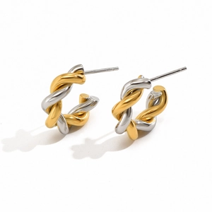 Detailed close-up of twisted C-shape earrings in polished two-tone gold and silver