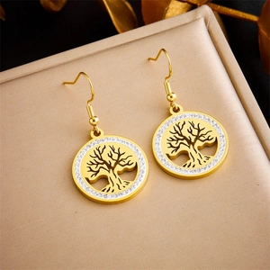 Detailed view of gold Tree of Life earrings with white rhinestones on jewelry box