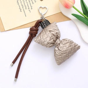 Champagne gold quilted leather bow keychain with braided strap and silver heart clasp