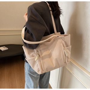 Dettaglio della borsa tote in velluto a coste bianco sporco con texture e tasche a zip