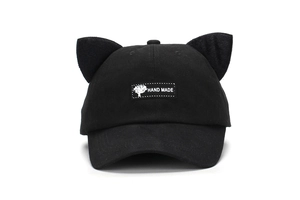 Close-up of black baseball cap with cute cat ears and woven Hand Made square label