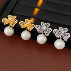 Detail of vintage flower earrings with pearls and zircon in gold and silver plating