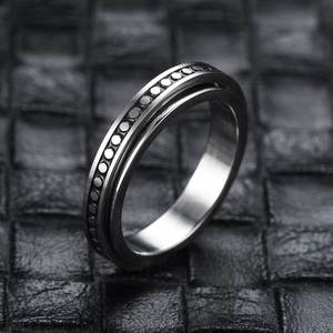 Macro view of stainless steel spinner ring with moon star texture on leather background