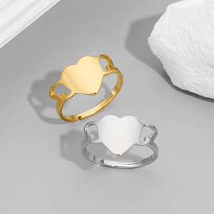 Detailed view of heart-shaped ring with angel wings in gold and silver finish