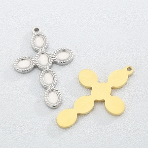 Detailed view of silver rope-edge and matte gold cross pendants on white texture