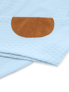 Detail of light blue diamond quilted fabric with brown faux suede patches and stitching